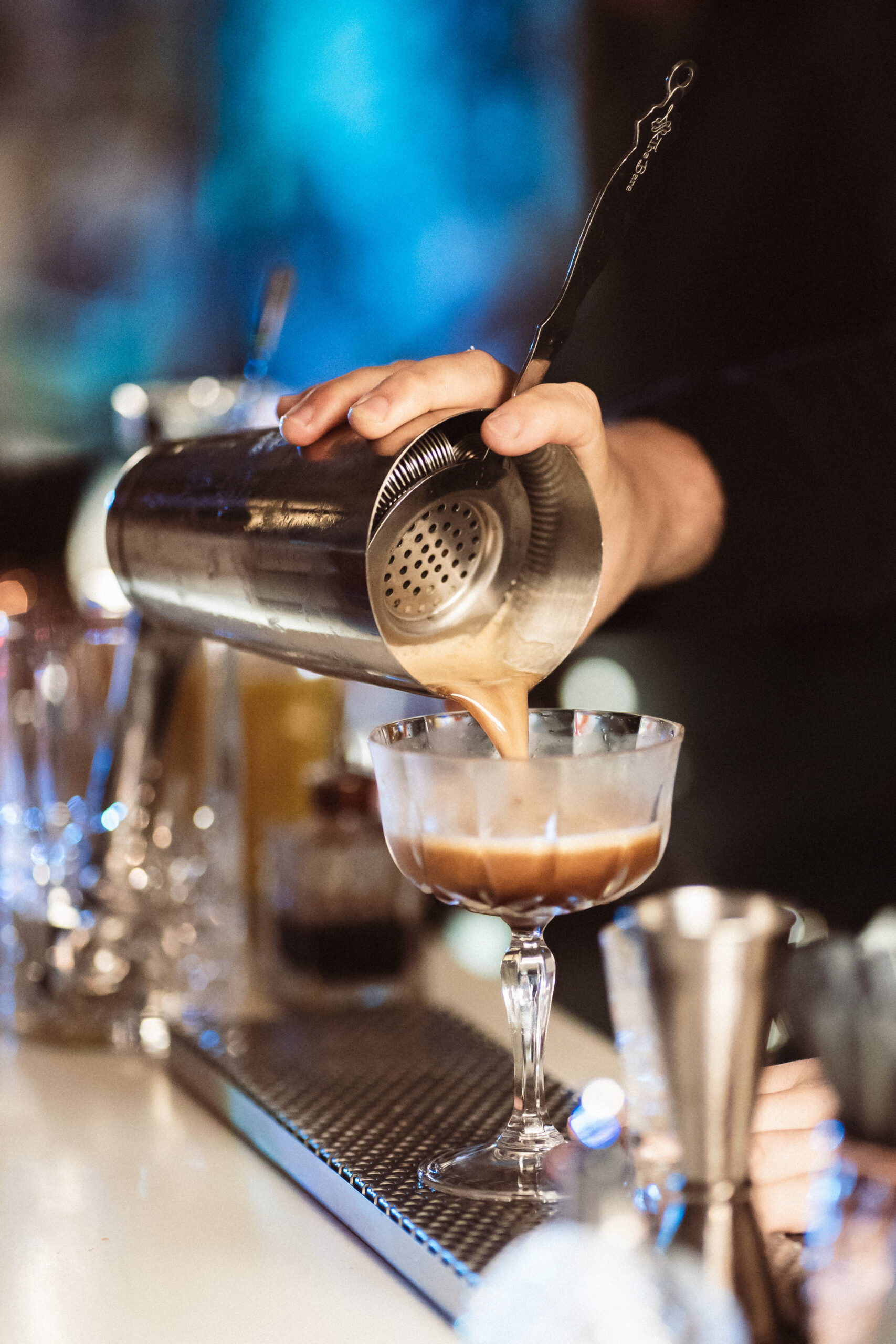 Bartender pouring creamy cocktail at elegant wedding bar in Italy
